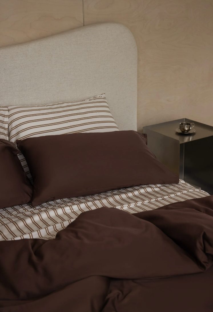 Bedroom in warm brown linen with striped pillows