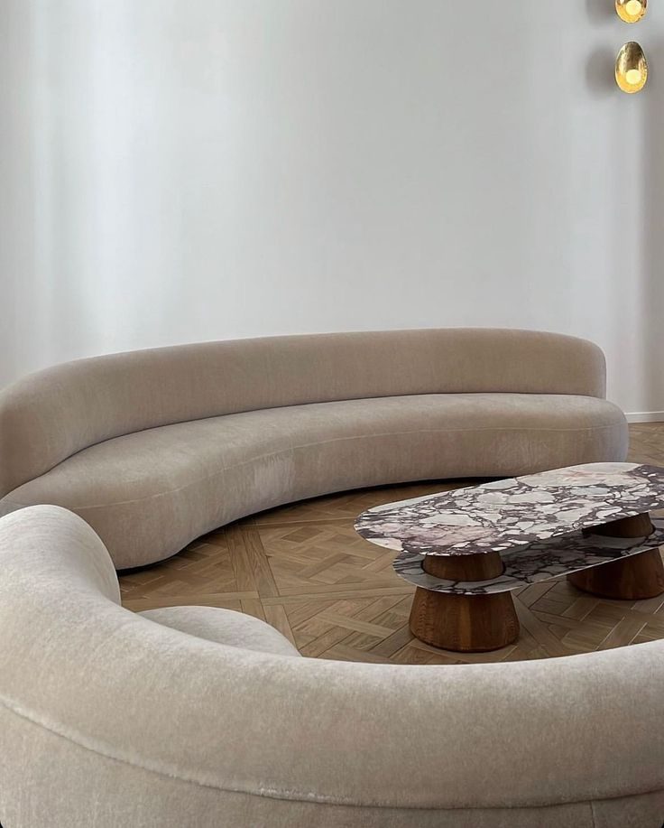 Curved cream sofa with a marble coffee table